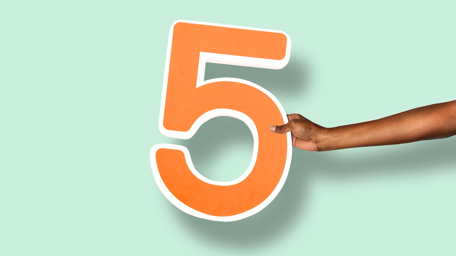 A hand holding the number 5